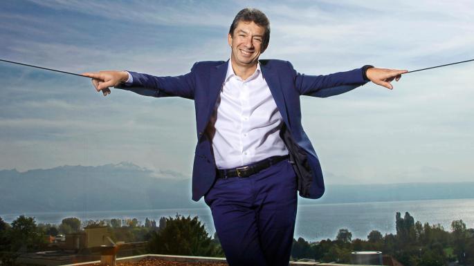 Andre Calantzopoulos posing in a white shirt and blue formal suit.